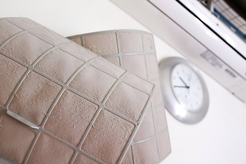 dirty air filters in front of a clock.