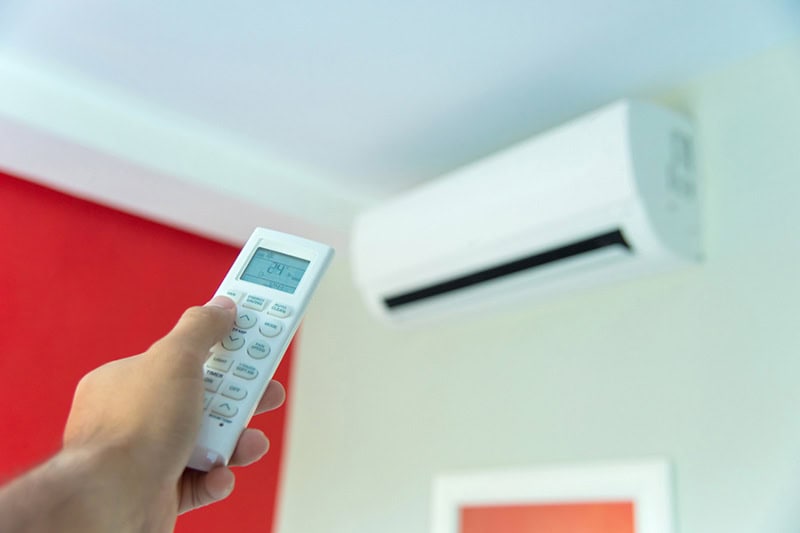 Hand with remote control cutting on ductless system